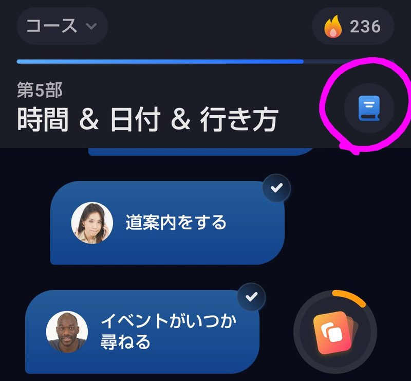 コースの画面。上に第5部 時間&日付&行き方と表示され、その右にある青いノートのマークがピンクの丸で囲まれている。下には道案内をする、イベントがいつか尋ねるの2つのレッスンが並んでいる